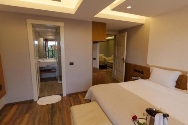 llogora tourist village masterbedroom with an bathroom and a lounge room